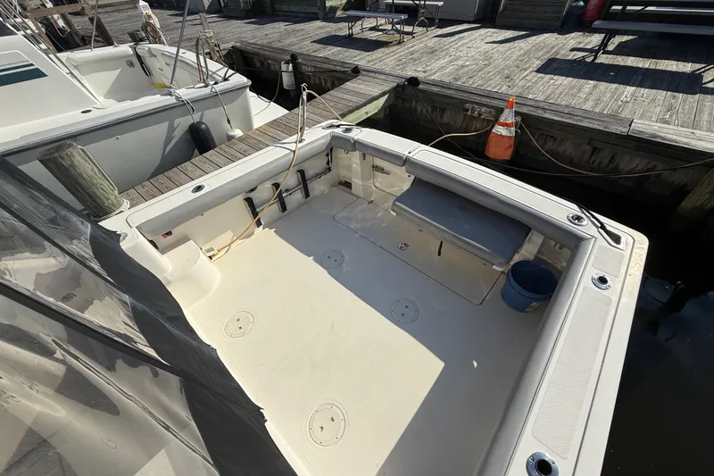 Slide: The Image of 2004 Pursuit 3100 Offshore boat docked, featuring spacious deck and seating area. - 8