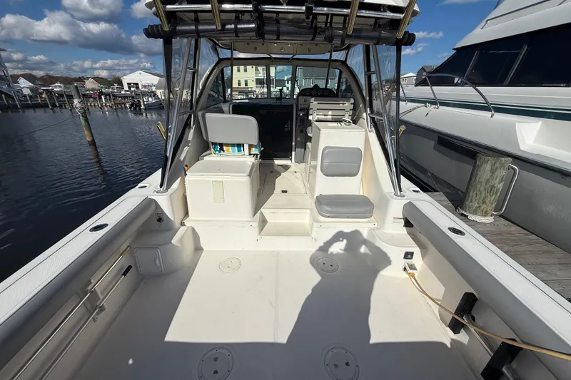 Slide: The Image of 2004 Pursuit 3100 Offshore boat interior with seating and helm, docked at marina. - 9