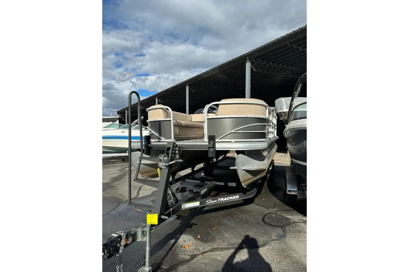 The Image of 2017 Sun Tracker Party Barge 20 DLX pontoon boat on trailer under cloudy sky. - 0