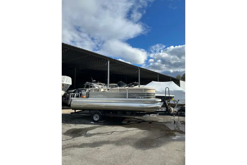 Slide: The Image of 2017 Sun Tracker Party Barge 20 DLX pontoon boat on trailer under cloudy sky. - 2