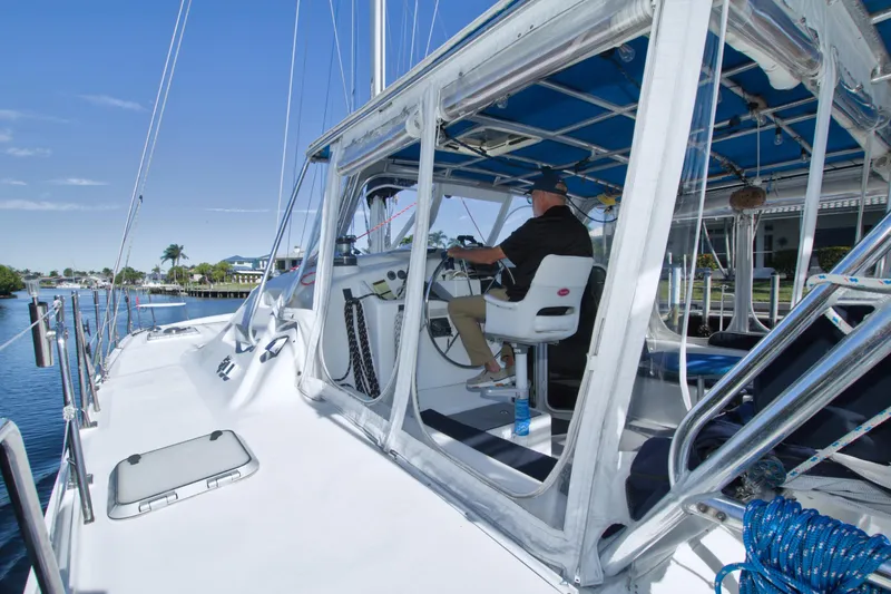 Slide: The Image of Man steering a 1996 Manta 40 sailboat on a sunny day. - 17