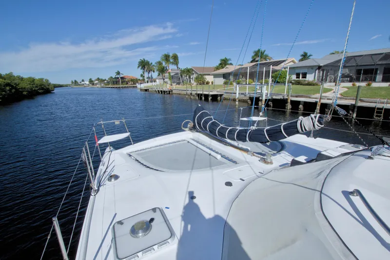 Slide: The Image of Sailing on a 1996 Manta 40 catamaran in a scenic canal with waterfront homes. - 19
