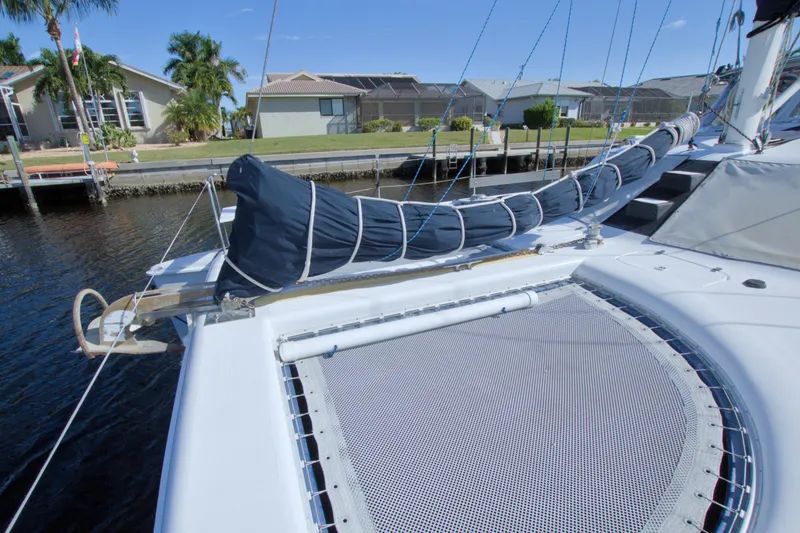 Slide: The Image of 1996 Manta 40 catamaran docked, featuring a covered sail and netted deck area. - 20
