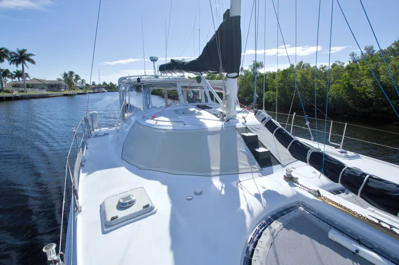 Slide: The Image of 1996 Manta 40 sailboat on a sunny day, docked by lush greenery. - 30