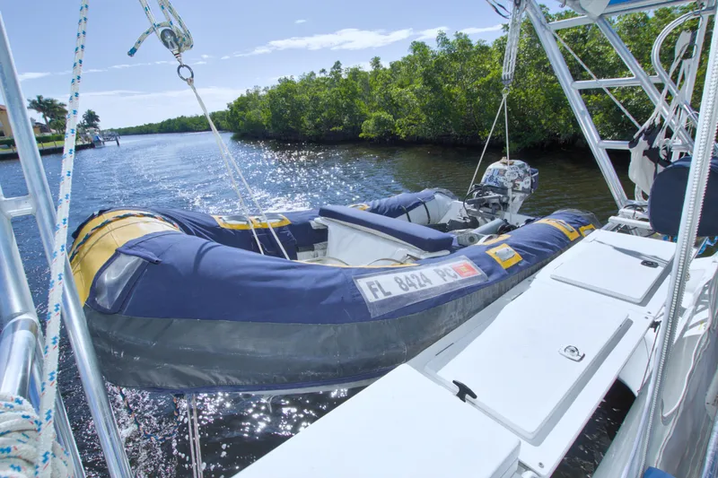 Slide: The Image of Inflatable boat on a 1996 Manta 40 catamaran, docked by a scenic waterway. - 38