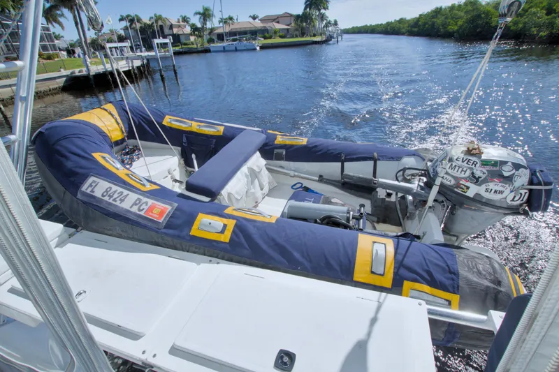 Slide: The Image of Inflatable boat on a 1996 Manta 40 yacht, docked by a scenic waterway. - 39