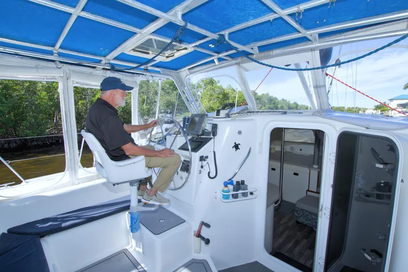 Slide: The Image of Man steering a 1996 Manta 40 sailboat under a blue canopy. - 41
