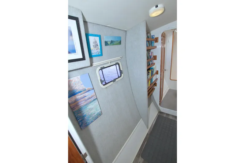 Slide: The Image of Interior of 1996 Manta 40 yacht with artwork, bookshelves, and a porthole window. - 57