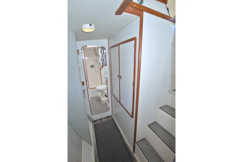 Slide: The Image of Interior of 1996 Manta 40 yacht, featuring bathroom and stairs with wooden accents. - 58