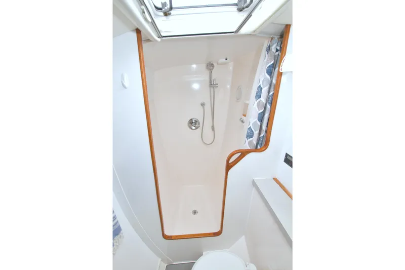 Slide: The Image of 1996 Manta 40 yacht bathroom with shower, white interior, and wooden trim. - 61