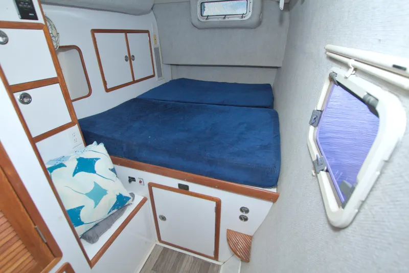 Slide: The Image of Cozy cabin interior of 1996 Manta 40 sailboat with blue bedding and storage. - 65