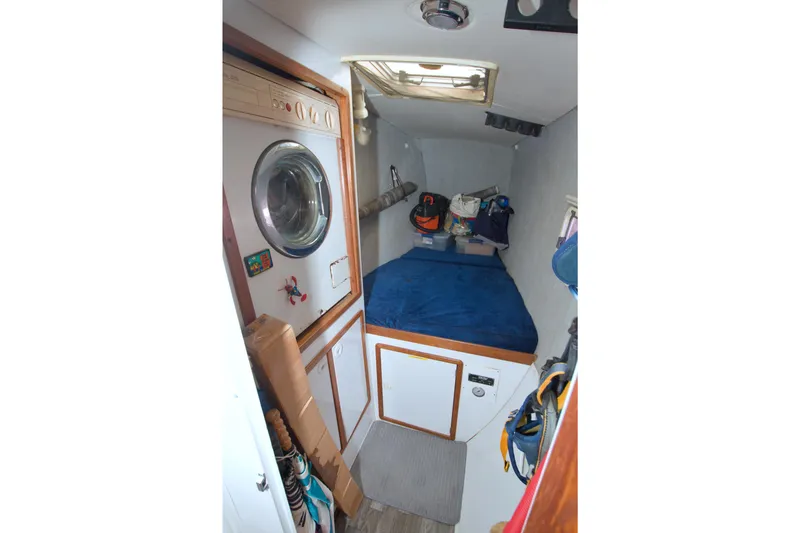 Slide: The Image of 1996 Manta 40 interior cabin with bed, storage, and washing machine. - 86