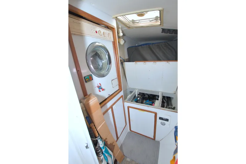Slide: The Image of Laundry area inside a 1996 Manta 40 yacht, featuring a washing machine and storage compartments. - 87