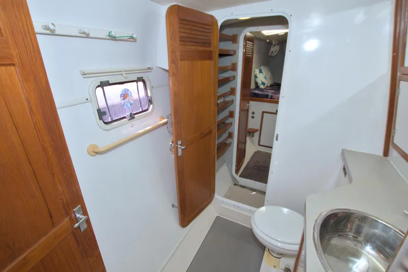 Slide: The Image of 1996 Manta 40 yacht bathroom with wooden doors, sink, and toilet. - 90