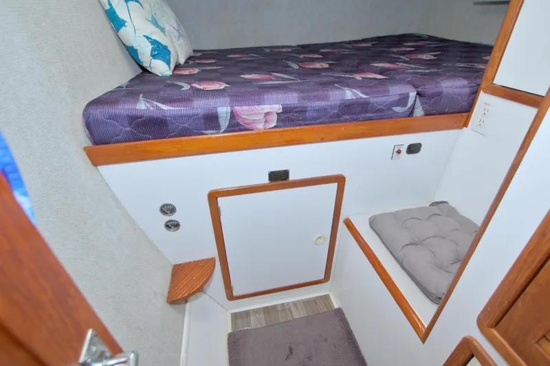 Slide: The Image of Cozy cabin interior of 1996 Manta 40 sailboat with purple bedding and wooden accents. - 94