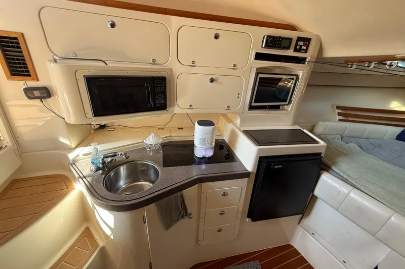 Slide: The Image of 2005 Grady-White Express 330 cabin interior with cozy seating and wooden table. - 16