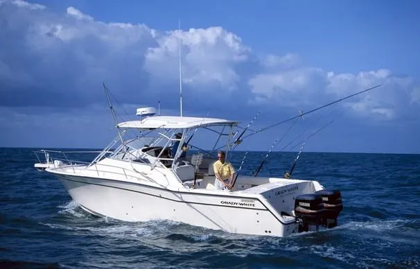 Slide: The Image of 2005 Grady-White Express 330 boat docked by a scenic waterfront with clear skies. - 2