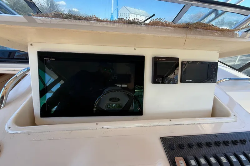 Slide: The Image of 2005 Grady-White Express 330 cabin interior with kitchenette, seating, and cozy sleeping area. - 21