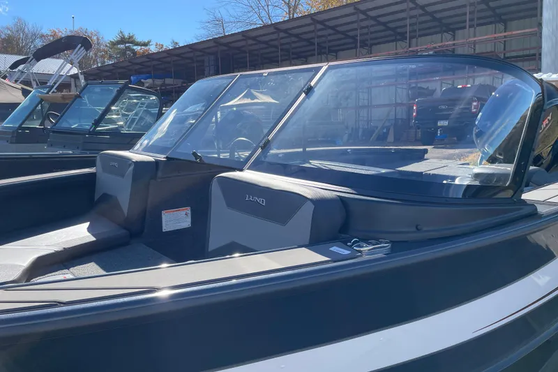 Slide: The Image of 2026 Lund 1875 Crossover XS boat with sleek design in a marina setting. - 6