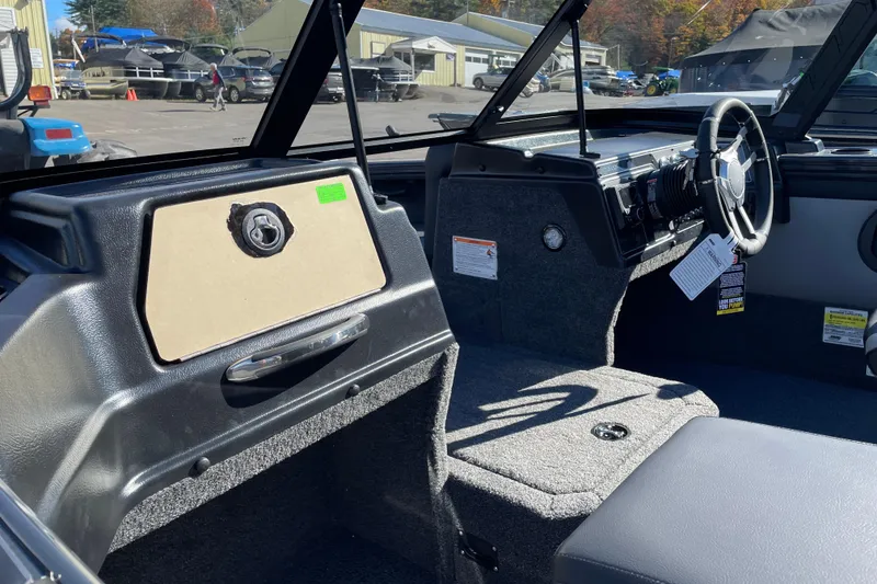 Slide: The Image of 2026 Lund 1875 Crossover XS boat interior with steering wheel and dashboard. - 9