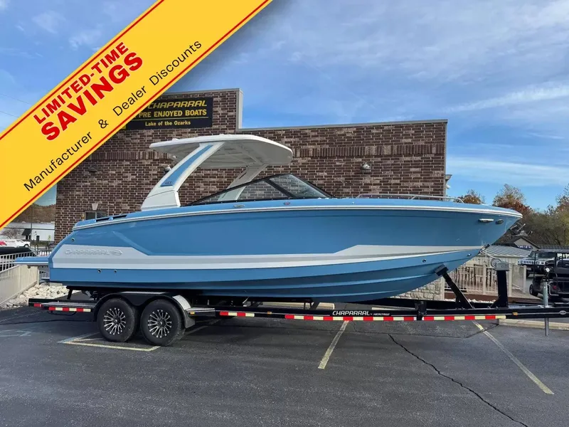 The Image of A blue and white Chaparral 30 SSX boat on a trailer in front of a building. - 1