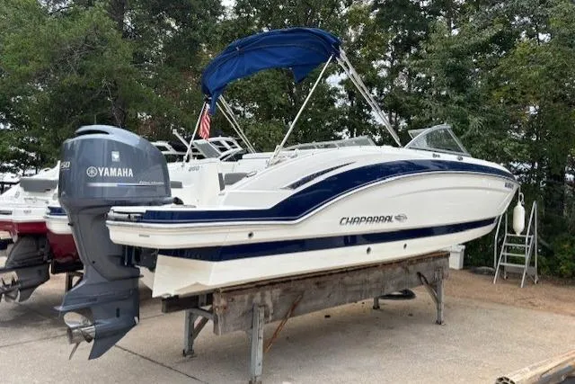 The Image of 2015 Chaparral 250 Suncoast boat with blue canopy, docked outdoors. - 0