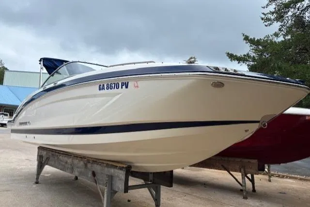 Slide: The Image of 2015 Chaparral 250 Suncoast boat with sleek blue and white design, docked outdoors. - 2