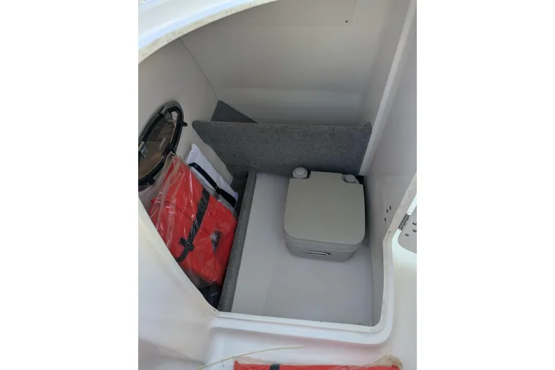Slide: The Image of Interior of 2015 Chaparral 250 Suncoast boat with storage and portable toilet. - 27