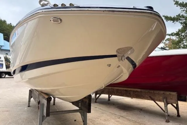 Slide: The Image of 2015 Chaparral 250 Suncoast boat on trailer, under blue sky, near trees and building. - 3