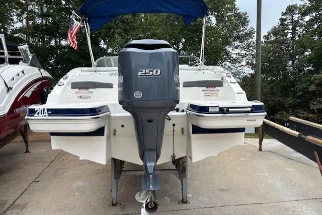 Slide: The Image of 2015 Chaparral 250 Suncoast boat on stands, beige hull with blue stripe. - 5