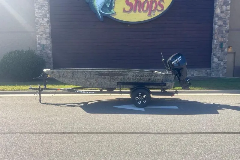 Slide: The Image of 2026 Tracker Grizzly 1650 T Prairie Wings Edition boat on trailer outside store. - 33