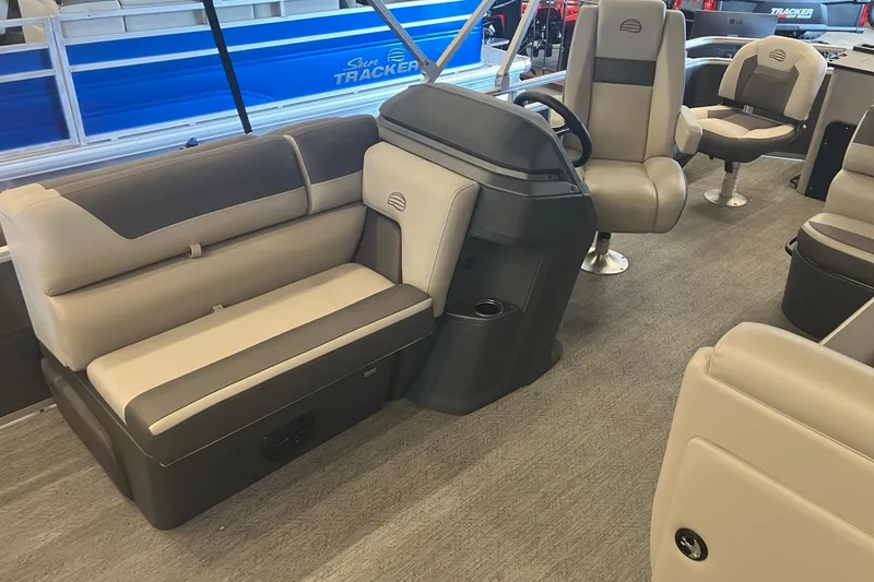 Slide: The Image of 2026 Sun Tracker Fishin' Barge 22 DLX interior with comfortable seating and steering console. - 2