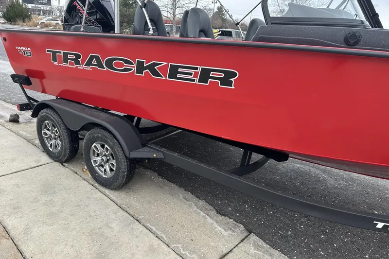 Slide: The Image of 2026 Tracker Targa V-19 Combo boat on trailer, red exterior, parked on pavement. - 10