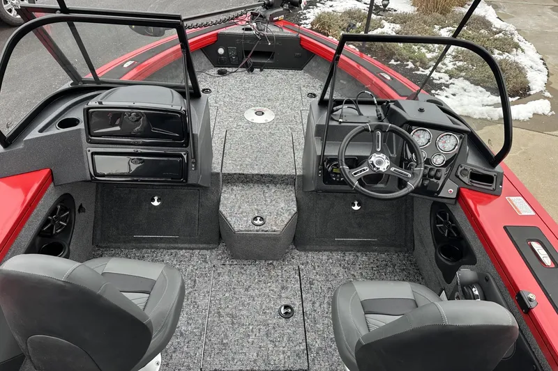 Slide: The Image of 2026 Tracker Targa V-19 Combo boat interior with open storage compartment and carpeted flooring. - 16