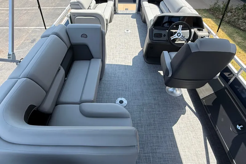 Slide: The Image of 2026 Sun Tracker SportFish 22 DLX pontoon boat interior with gray seating and steering console. - 14