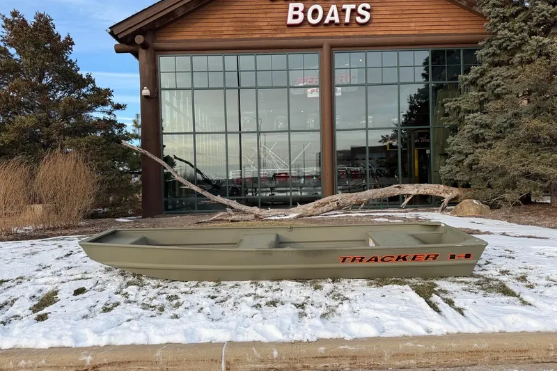 The Image of 2026 Tracker Grizzly 14 Jon boat displayed outside a boat dealership in winter. - 0