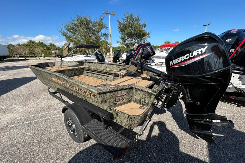 Slide: The Image of 2026 Tracker Grizzly 1756 T Marsh boat with Mercury engine in outdoor setting. - 2