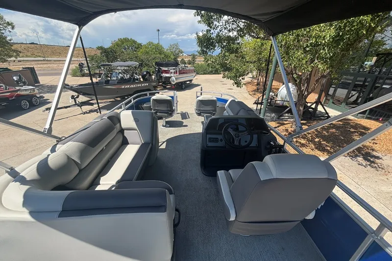 Slide: The Image of 2026 Sun Tracker Fishin' Barge 20 DLX pontoon boat interior with seating and steering console. - 15