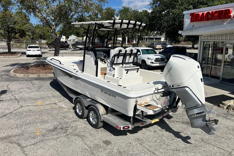 Slide: The Image of 2026 Ranger 2360 Bay boat with Mercury engine on a trailer in a parking lot. - 2