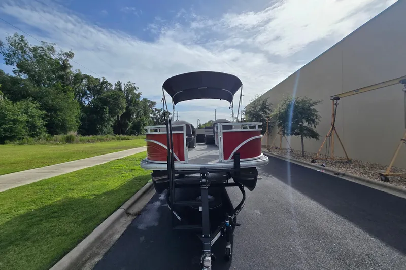 Slide: The Image of 2026 Sun Tracker Fishin' Barge 22 DLX pontoon boat on trailer, parked outdoors. - 65