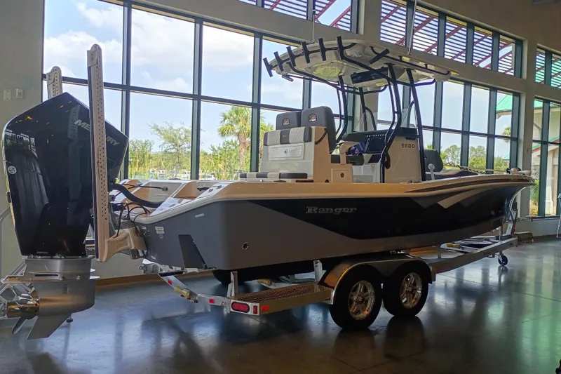 Slide: The Image of 2026 Ranger 2600 Bay boat displayed indoors with dual engines and trailer. - 3