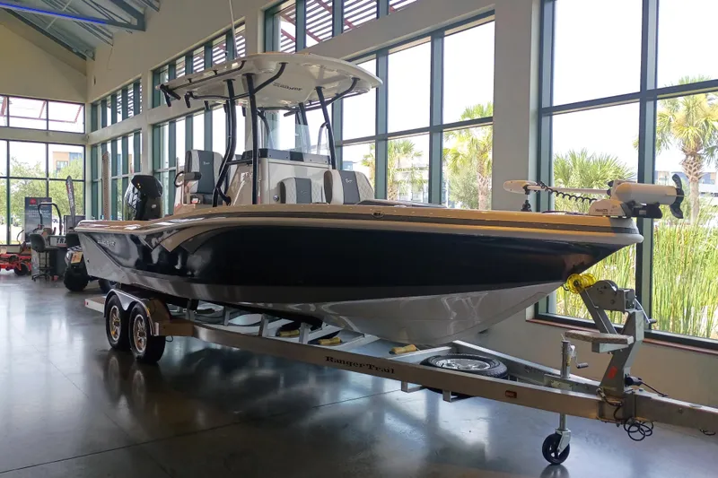 The Image of 2026 Ranger 2600 Bay boat on trailer in showroom, large windows in background. - 0