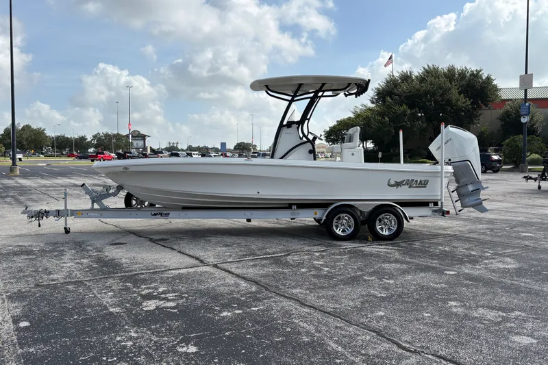 Slide: The Image of 2026 Mako 24 APEX boat on trailer in parking lot under cloudy sky. - 3