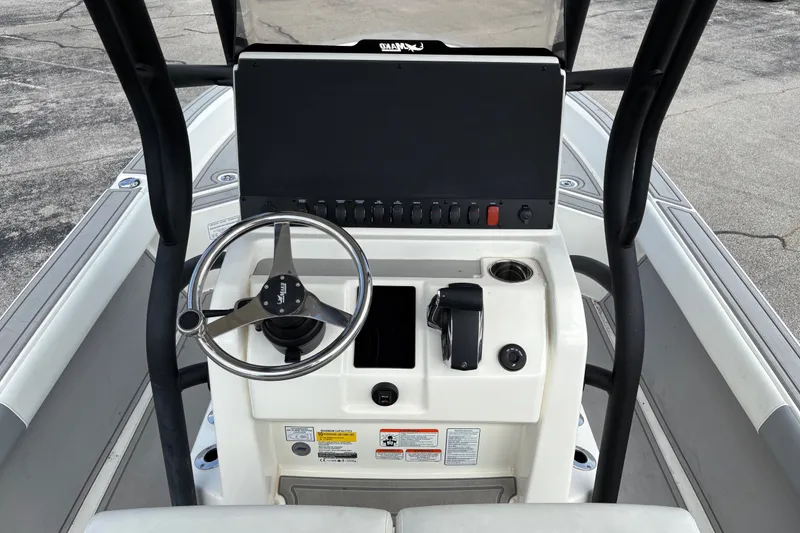 Slide: The Image of Steering console of 2026 Mako 24 APEX boat with controls and display panel. - 102
