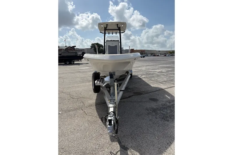 Slide: The Image of Front view of 2026 Mako 24 APEX boat on trailer under a cloudy sky. - 1