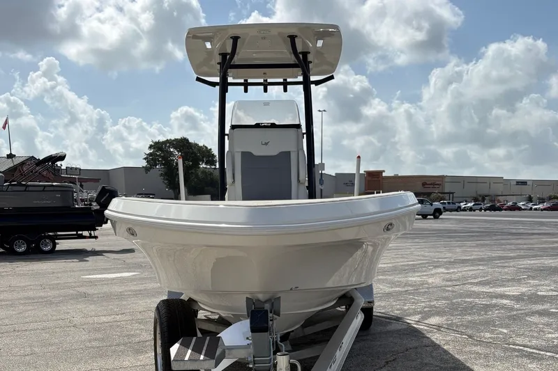 Slide: The Image of Front view of 2026 Mako 24 APEX boat on trailer under a cloudy sky. - 1