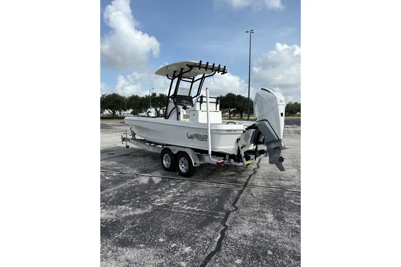 Slide: The Image of 2026 Mako 24 APEX boat on trailer, parked outdoors under cloudy sky. - 101