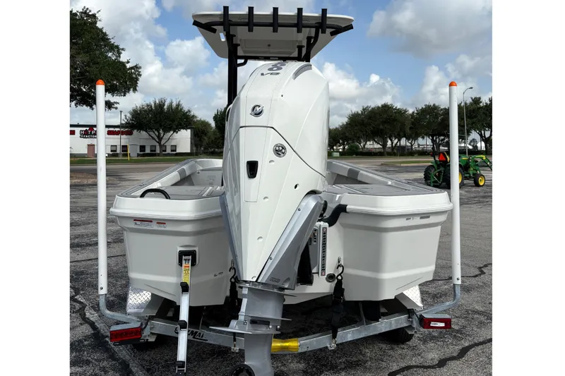 Slide: The Image of 2026 Mako 24 APEX boat on trailer, rear view, under a cloudy sky. - 3