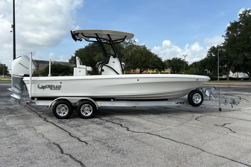 Slide: The Image of 2026 Mako 24 APEX boat on trailer, parked outdoors under a cloudy sky. - 7
