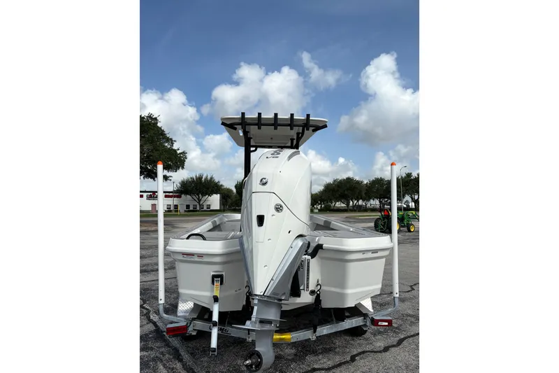 Slide: The Image of 2026 Mako 24 APEX boat on trailer, rear view, under a cloudy sky. - 4